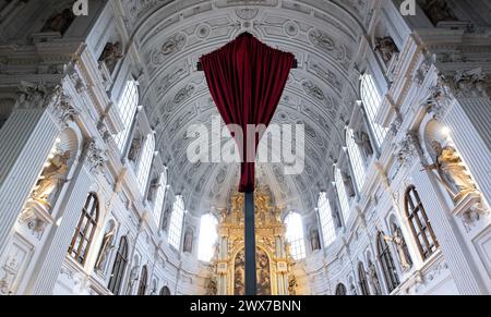 Munich, Allemagne. 28 mars 2024. Un tissu rouge recouvre la croix devant l'autel en équipé Michael's Church. Dans de nombreuses églises, les représentations de Jésus sont voilées à l'approche de Pâques, pour être dévoilées cérémonieusement à nouveau lors d'un service religieux le vendredi Saint. Crédit : Sven Hoppe/dpa/Alamy Live News Banque D'Images