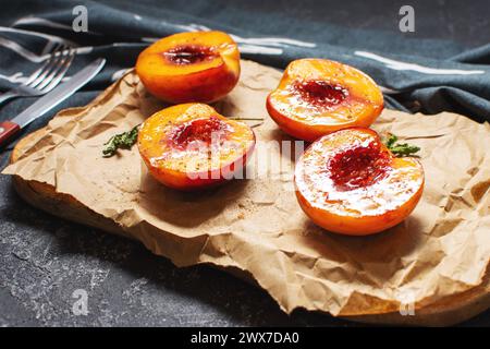 Pêches cuites au four avec miel et cannelle sur fond de pierre noire. dessert d'été Banque D'Images