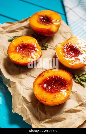 Pêches cuites au four avec du miel et de la cannelle sur fond de bois bleu. dessert d'été Banque D'Images