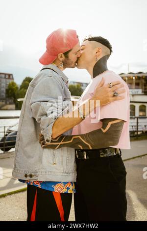 Vue latérale d'un couple gay s'embrassant tout en se tenant debout sur la promenade Banque D'Images