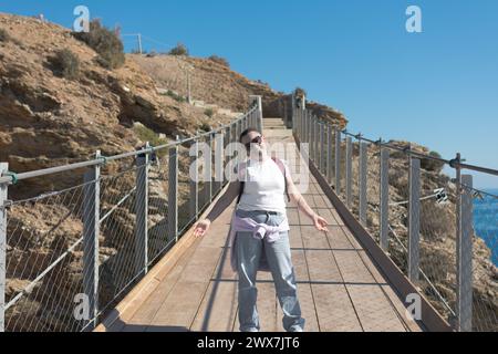 femme adulte posant sur le pont suspendu Banque D'Images