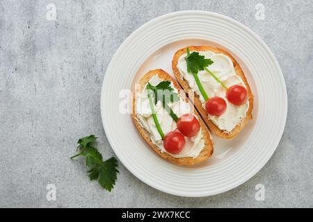 Toast drôle en forme de sandwich aux cerises mûres avec fromage à la crème, pain, tomate cerise, oignon et persil. Idée d'art alimentaire pour la nourriture des enfants. Pause créative Banque D'Images