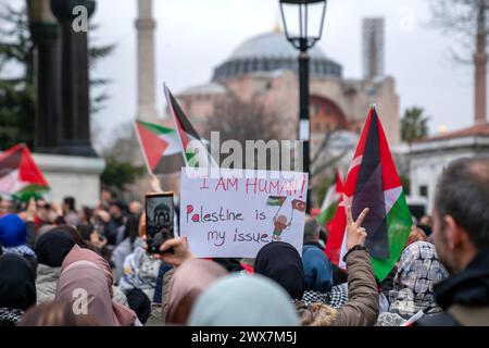 Fatih, Istanbul, Turquie. 28 mars 2024. Un manifestant porte une banderole avant une marche pro-palestinienne sur la place Sultanahmet le 28 mars 2024, avec la mosquée Sainte-Sophie en arrière-plan. (Crédit image : © Tolga Uluturk/ZUMA Press Wire) USAGE ÉDITORIAL SEULEMENT! Non destiné à UN USAGE commercial ! Banque D'Images