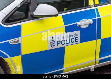 Angle bas, vue latérale gros plan de la voiture de police de West Mercia (côté passager, côté proche) garée isolée à l'extérieur sans personne. Véhicule d'intervention en cas d'incident. Banque D'Images