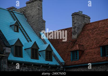 Toits colorés avec lucarnes et cheminées en pierre de bâtiments résidentiels contre un ciel bleu dans le Vieux-Québec historique dans la ville de Québec, Canada Banque D'Images