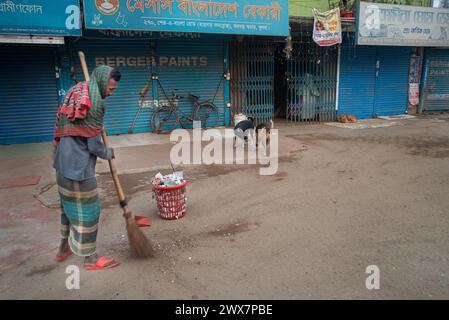 Un nettoyeur de la corporation municipale, est vu balayer les rues le matin à Khulna, au Bangladesh. Banque D'Images