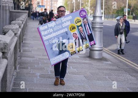 Le porte-parole du Sinn Fein en matière de logement, Eoin O Broin, devant les bâtiments du gouvernement à Dublin, alors qu'il organise une manifestation « pas de porte » contre le niveau record d'enfants et d'adultes dans les logements d'urgence. Date de la photo : jeudi 28 mars 2024. Banque D'Images