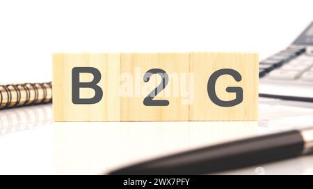 Les lettres B2G sur cubes en bois sur fond blanc Banque D'Images