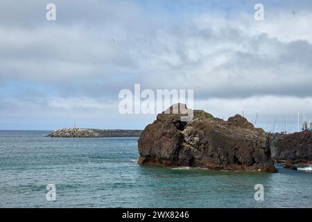 Les tétrapodes au bord de la mer dans la ville de Ponta Delgada protègent la côte des vagues. Belles vues sur la mer, les montagnes, les nuages et les brise-lames. San Banque D'Images