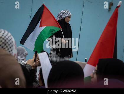 Beyrouth, Liban. 27 mars 2024. Une palestinienne tient un drapeau palestinien lors d'une manifestation à Beyrouth, au Liban, le 27 mars 2024 contre le traitement prétendument réservé par l'UNRWA à ses employés pro-palestiniens. (Photo de Collin Mayfield/Sipa USA) crédit : Sipa USA/Alamy Live News Banque D'Images