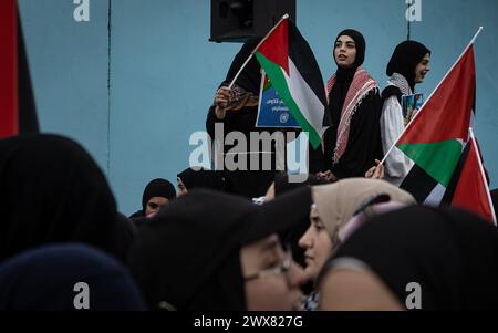 Beyrouth, Liban. 27 mars 2024. Des femmes palestiniennes brandissent des drapeaux palestiniens lors d'une manifestation à Beyrouth, Liban, le 27 mars 2024 contre le traitement prétendument réservé par l'UNRWA à ses employés pro-palestiniens. (Photo de Collin Mayfield/Sipa USA) crédit : Sipa USA/Alamy Live News Banque D'Images