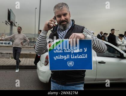 Beyrouth, Liban. 27 mars 2024. Un palestinien tient une pancarte indiquant "pas de compromis sur notre appartenance nationale" lors d'une manifestation à Beyrouth, Liban, le 27 mars 2024 contre le traitement allégué par l'UNRWA des employés pro-palestiniens. (Photo de Collin Mayfield/Sipa USA) crédit : Sipa USA/Alamy Live News Banque D'Images