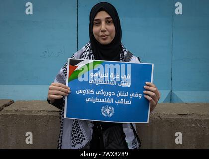 Beyrouth, Liban. 27 mars 2024. Une jeune fille palestinienne tient une pancarte indiquant "a Gaza Netanyahu tue le palestinien, au Liban Dorothee Klaus [Directrice des affaires de l'UNRWA, Liban] punit le palestinien" lors d'une manifestation à Beyrouth, Liban, le 27 mars 2024 contre le traitement par l'UNRWA des employés pro-palestiniens. (Photo de Collin Mayfield/Sipa USA) crédit : Sipa USA/Alamy Live News Banque D'Images