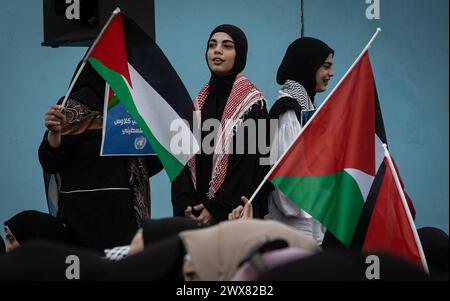 Beyrouth, Liban. 27 mars 2024. Des femmes palestiniennes brandissent des drapeaux palestiniens lors d'une manifestation à Beyrouth, Liban, le 27 mars 2024 contre le traitement prétendument réservé par l'UNRWA à ses employés pro-palestiniens. (Photo de Collin Mayfield/Sipa USA) crédit : Sipa USA/Alamy Live News Banque D'Images