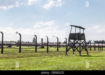 Clôtures barbelées, tour de garde et caserne des prisonniers au camp de concentration nazi Auschwitz-Birkenau, Pologne Banque D'Images