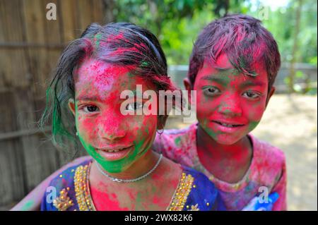 Sylhet, Bangladesh. 26 mars 2024. Les enfants dans un jardin de thé avec des visages peints aux couleurs de l'arc-en-ciel célébrant le festival annuel des couleurs hindous, connu sous le nom de festival Holi, marquant le début du printemps. Le 26 mars 2024 Sylhet, Bangladesh (photo de MD Rafayat Haque Khan/ Eyepix Group/Sipa USA) crédit : Sipa USA/Alamy Live News Banque D'Images