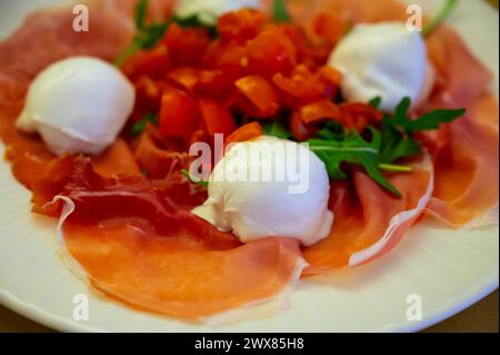 Cuisine de la région Emilie-Romagne, salade Caprese avec Prosciutto crudo, prosciutto di Parma, mozzarella et tomates, déjeuner à Parme, Italie Banque D'Images