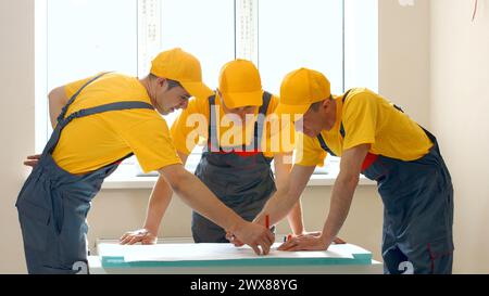 Brigade de la grande entreprise de construction discute du projet. Les ingénieurs regardent projet. Banque D'Images