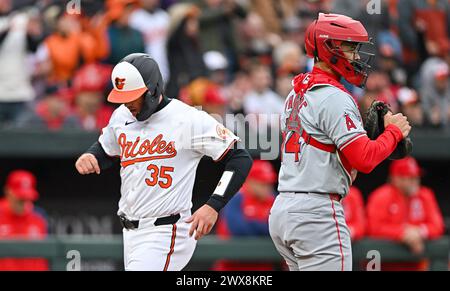 Baltimore, États-Unis. 28 mars 2024. Adley Rutschman (35), le receveur des Orioles de Baltimore, marque devant Logan O'Hoppe (14), le receveur des Angels de Los Angeles, lors de la première manche de l'ouverture à domicile de la saison régulière à Camden Yards à Baltimore, Maryland, le jeudi 28 mars 2024. Photo de David Tulis/UPI crédit : UPI/Alamy Live News Banque D'Images