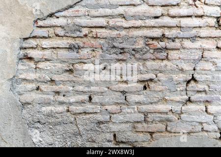 L'image représente un mur de briques vieilli, ses couleurs autrefois vibrantes se sont estompées au fil du temps, lui donnant un look vintage qui raconte une histoire de vieillissement et de PA du temps Banque D'Images