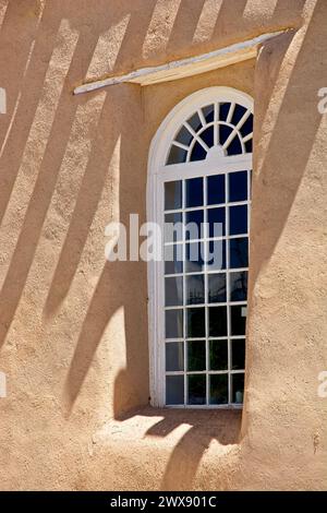 Fenêtre palladienne encastrée dans d'épais murs en adobe avec des ombres de poutres de toit en viga de l'église de la mission de San Francisco de Assisi Banque D'Images