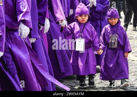 Antigua, Guatemala. 28 mars 2024. De jeunes garçons marchent aux côtés de leurs parents en transportant l’énorme flotteur processionnel Jesús Nazareno del Perdón depuis l’église San Francisco El Grande à Semana Santa, le 28 mars 2024 à Antigua, au Guatemala. Les processions opulentes, les algèbres détaillées et les traditions séculaires attirent plus d'un million de personnes dans l'ancienne capitale. Crédit : Richard Ellis/Richard Ellis/Alamy Live News Banque D'Images