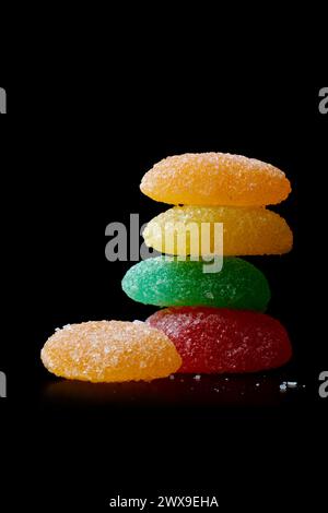 jujubes, confiserie de bonbons à mâcher gélifiés colorés aromatisés aux fruits avec fond noir isolé empilé de forme allongée avec espace de copie Banque D'Images