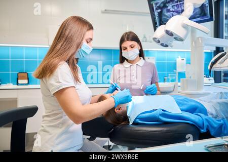 Assistant aide un dentiste à un rendez-vous Banque D'Images