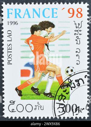 Timbre-poste oblitéré imprimé par le Laos, qui promeut le football, Coupe du monde de la FIFA, France -1998, circa 1996. Banque D'Images