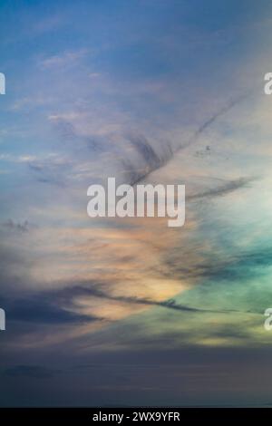 Les nuages de cirrus attrapent la lumière du soleil avec des nuages sombres qui les traversent Banque D'Images