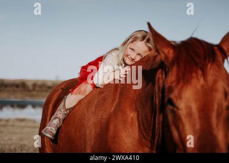 Charme blonde : fille de 4 ans et son cheval Forge Unbreakable Bond! Banque D'Images