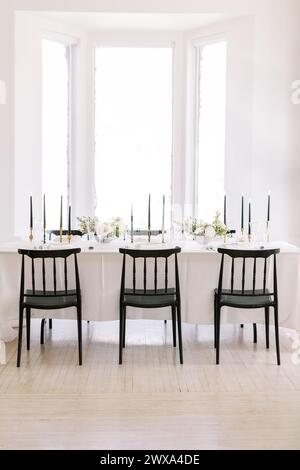 Table de réception sereine de mariage avec d'élégantes chaises noires Banque D'Images