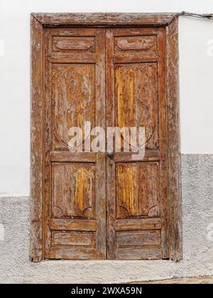 Vieille porte d'entrée altérée en bois brun avec peinture écaillée. Banque D'Images