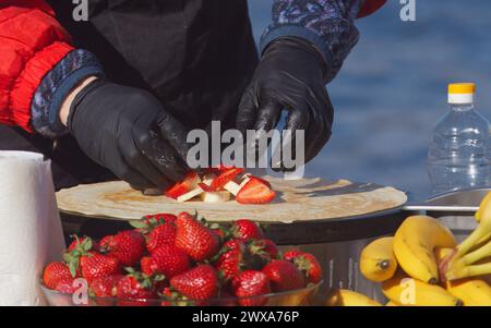 Le corps de la section médiane d'un chef préparant des crêpes de fruits sucrés, des crêpes françaises au marché fermier Stall à Prague Naplavka, République tchèque Banque D'Images