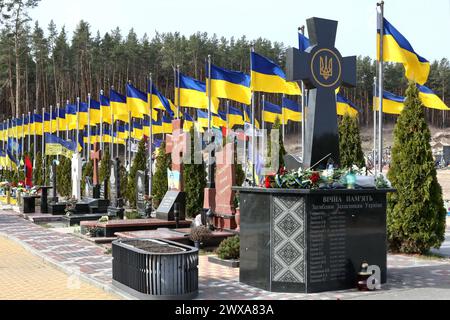 Irpin, UKRAINE - 28 MARS 2024 - des drapeaux nationaux flottent sur les tombes des défenseurs périmés de l'Ukraine au cimetière de la ville d'Irpin à l'occasion du deuxième anniversaire de la libération de la ville des envahisseurs russes, Irpin, région de Kiev, dans le nord de l'Ukraine. Banque D'Images