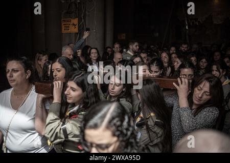 Jérusalem, Israël. 29 mars 2024. Les fidèles chrétiens marchent avec une croix pendant la procession du vendredi Saint. Crédit : Ilia Yefimovich/dpa/Alamy Live News Banque D'Images