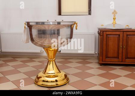 Baptême font avec de l'eau avec serviette dans une église orthodoxe. L'intérieur de la salle pour le baptême des enfants dans l'Église orthodoxe. Banque D'Images