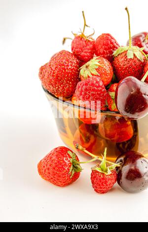 Un mélange de petits fruits rouges appétissants dans un bol. Mise au point sélective avec faible profondeur de champ. Banque D'Images