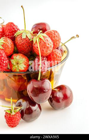 Un mélange de petits fruits rouges appétissants dans un bol. Mise au point sélective avec faible profondeur de champ. Banque D'Images