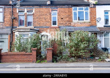 Jardins envahis devant des maisons mitoyennes à Crewe UK Banque D'Images