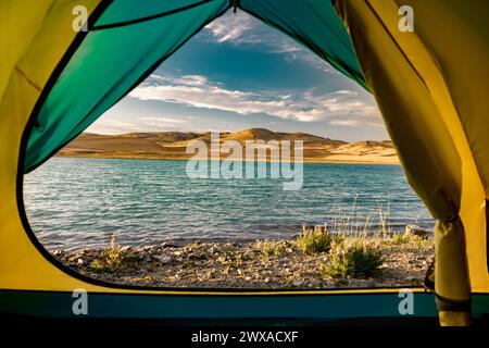 Belle vue depuis la tente au lac tranquille avec de l'eau turquoise et des dunes de sable contre le ciel bleu Banque D'Images