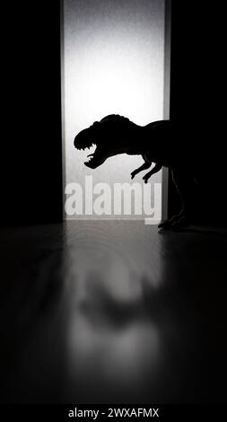 T Rex dinosaure avec des dents pointues debout dans la chambre sombre Banque D'Images