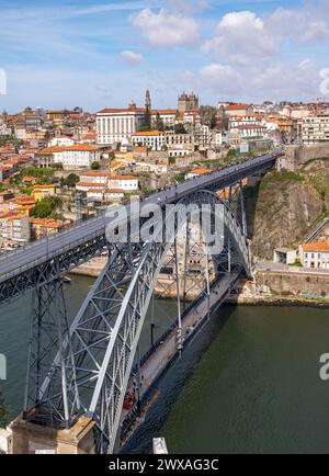 L'emblématique pont Dom Luís I enjambe le fleuve Douro, avec le quartier de Ribeira en arrière-plan, Porto, Portugal. Banque D'Images