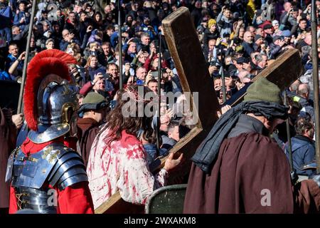 Kalwaria Zabrzydowska, Pologne, 29 mars 2024. Un acteur porte une croix alors que des milliers de dévots marchent sur le chemin de la procession de la Croix le vendredi Saint dans le site classé par l'UNESCO dans la basilique Kalwaria Zebrzydowska. La procession traditionnelle sur le site commence tôt le matin avec des acteurs payant les rôles bibliques du chemin de Croix. Crédit : Dominika Zarzycka/Alamy Live News Banque D'Images