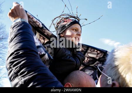 Kalwaria Zabrzydowska, Pologne, 29 mars 2024. Mère couvre son fils d'une couverture alors qu'ils marchent sur le chemin de la procession de Croix le vendredi Saint dans le monument, site classé par l'UNESCO dans la basilique Kalwaria Zebrzydowska. La procession traditionnelle sur le site commence tôt le matin avec des acteurs payant les rôles bibliques du chemin de Croix. Crédit : Dominika Zarzycka/Alamy Live News Banque D'Images