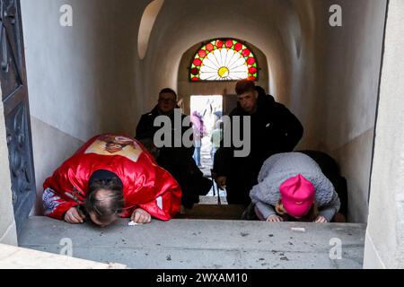 Kalwaria Zabrzydowska, Pologne, 29 mars 2024. Les dévots embrassent les escaliers alors qu'ils marchent sur le chemin de la procession de la Croix le vendredi Saint dans le monument, site classé au patrimoine mondial de l'UNESCO dans la basilique Kalwaria Zebrzydowska. La procession traditionnelle sur le site commence tôt le matin avec des acteurs payant les rôles bibliques du chemin de Croix. Crédit : Dominika Zarzycka/Alamy Live News Banque D'Images