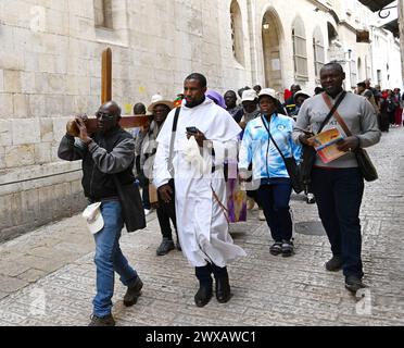 Vieille ville Jérusalem, Israël. 29 mars 2024. Les touristes chrétiens d’Afrique portent une croix sur la via Dolorosa, le chemin de Croix, dans la vieille ville de Jérusalem le vendredi Saint 29 mars 2024. Photo de Debbie Hill/ crédit : UPI/Alamy Live News Banque D'Images