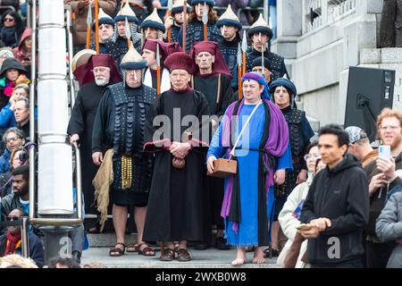 Londres, Royaume-Uni. 29 mars 2024. Les acteurs jouant Judas et le personnel du temple jouant le rôle des joueurs de Wintershall interprètent « la passion de Jésus », qui commémore le jour où Jésus-Christ a été arrêté, jugé et crucifié par les Romains avant de ressusciter d’entre les morts le dimanche de Pâques. Une troupe de plus de 100 acteurs et bénévoles, ainsi que des chevaux, des ânes et des colombes, donne vie à l'histoire à Trafalgar Square. Credit : Stephen Chung / Alamy Live News Banque D'Images