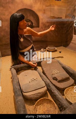 Exposition montrant une femme indigène broyant du maïs au Bandelier National Monument, Nouveau-Mexique, États-Unis [pas de publication ; licence éditoriale uniquement] Banque D'Images