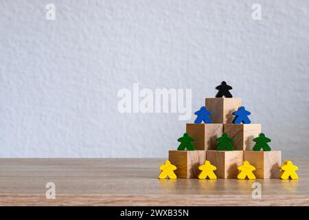 Blocs de bois disposés en pyramide avec des figures colorées placées stratégiquement. Banque D'Images